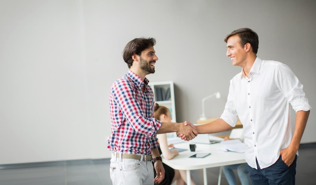 Two colleagues shaking hands in an office